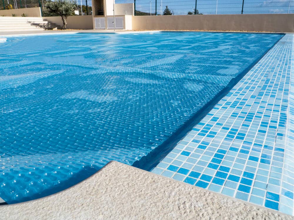 The cover of swimming pool which also lets the pool heat up from the sun. - What Does a Pool Cover Actually Do?